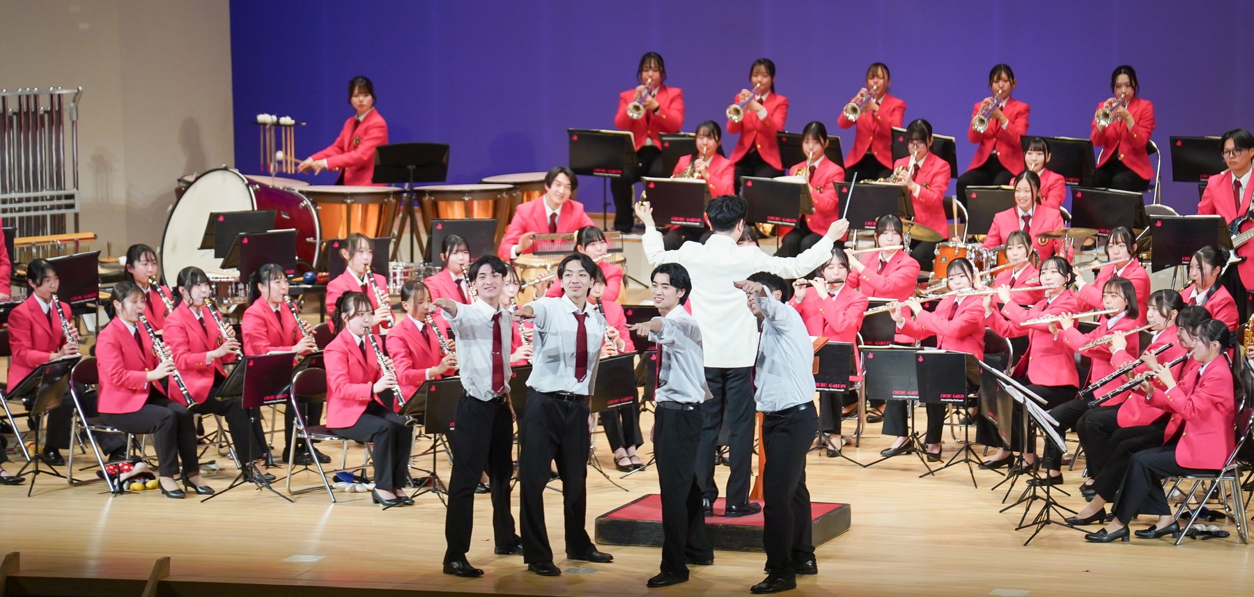 定期演奏会で、ステージ前に立った部員が演出を交えて演奏する様子